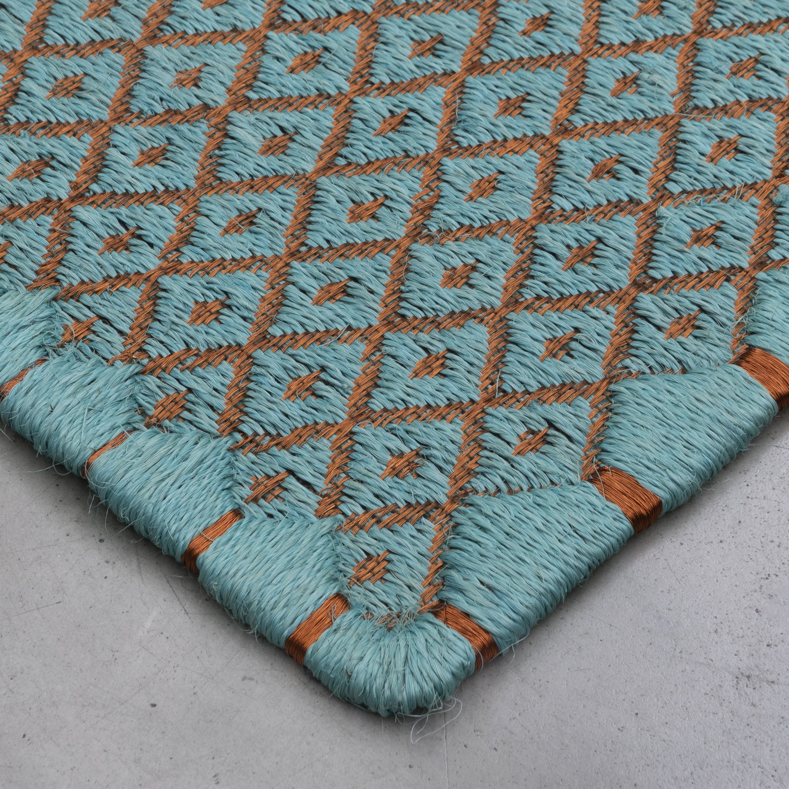 RHOMBUS WEAVE RUG IN LIGHT TURQUOISE FIQUE FIBER AND COPPER