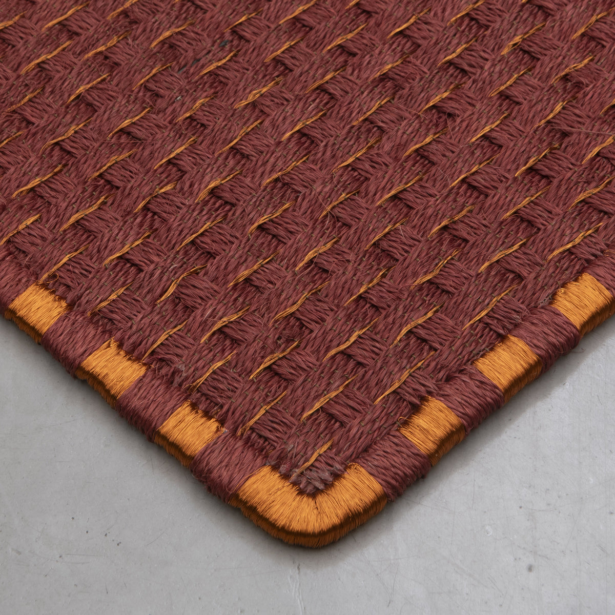 KANASPI WEAVE RUG IN BURGUNDY FIQUE FIBER AND COPPER